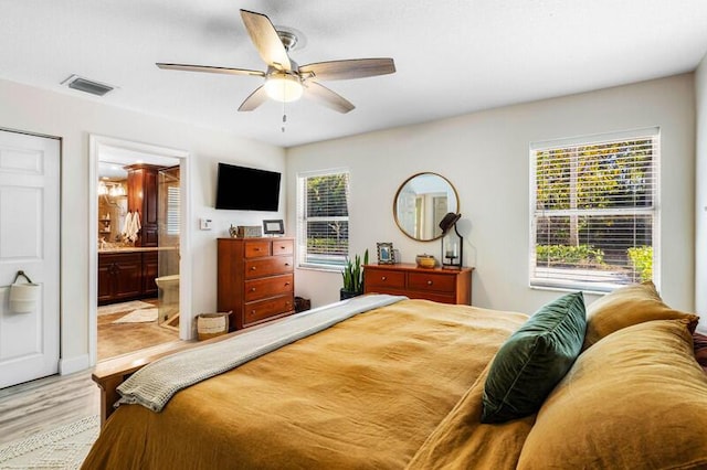 bedroom featuring visible vents, connected bathroom, ceiling fan, and wood finished floors