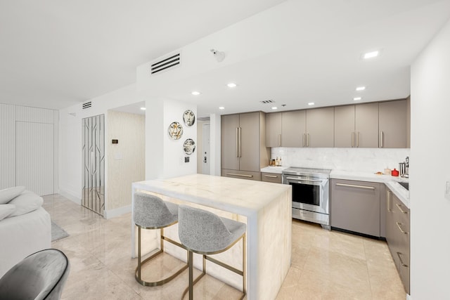 kitchen with backsplash, open floor plan, light countertops, gray cabinets, and stainless steel electric range