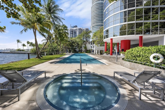 pool with a city view, a water view, a patio, and a community hot tub