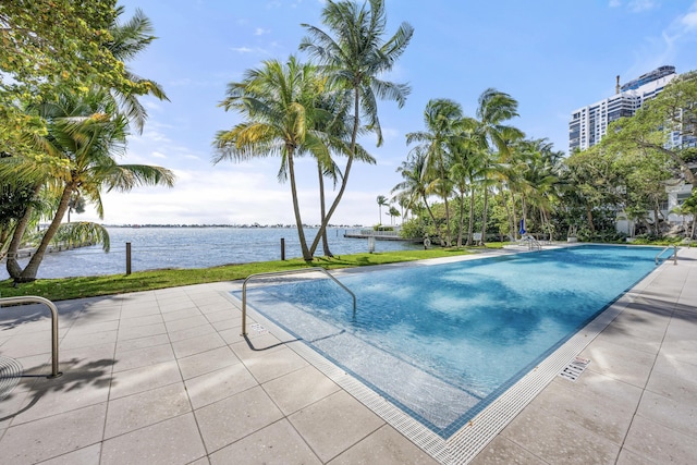 community pool with a patio and a water view