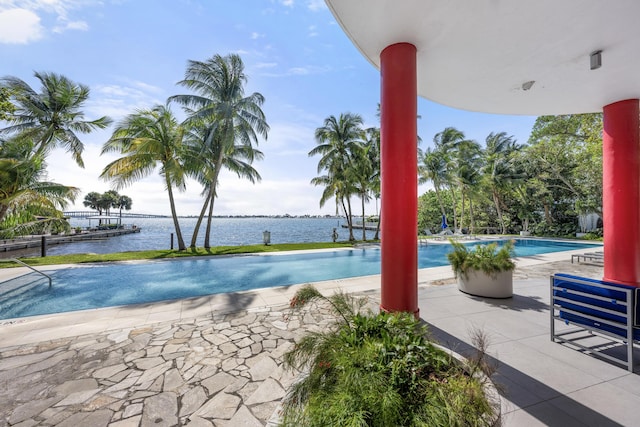 pool featuring a patio and a water view