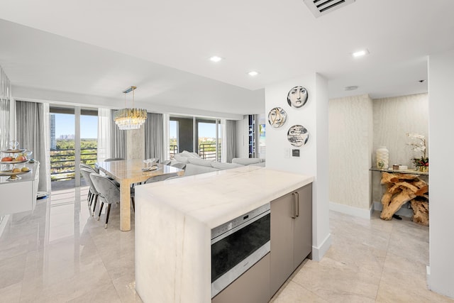 kitchen featuring decorative light fixtures, a notable chandelier, visible vents, and a wealth of natural light