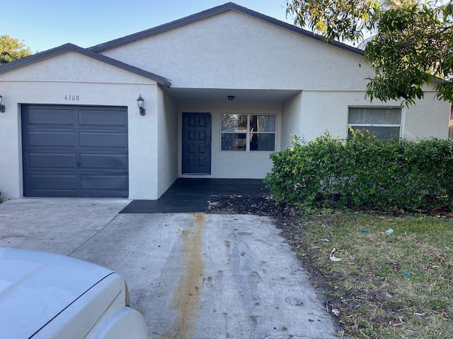 single story home with stucco siding, driveway, and a garage