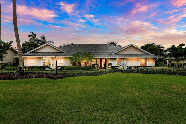 single story home with a yard and stucco siding