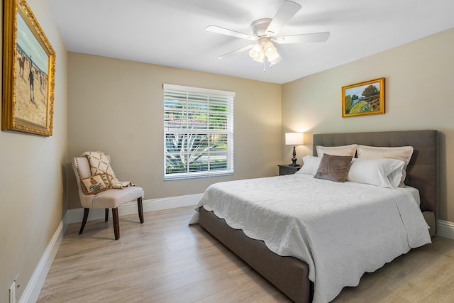 bedroom with light wood-style flooring, baseboards, and ceiling fan