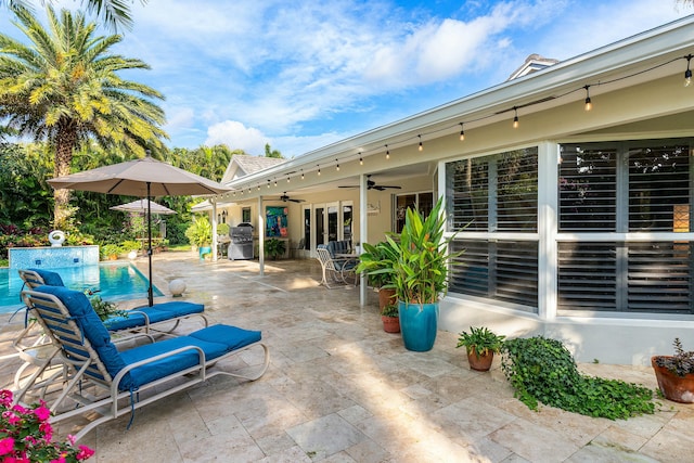 view of patio with a ceiling fan, an outdoor pool, and grilling area