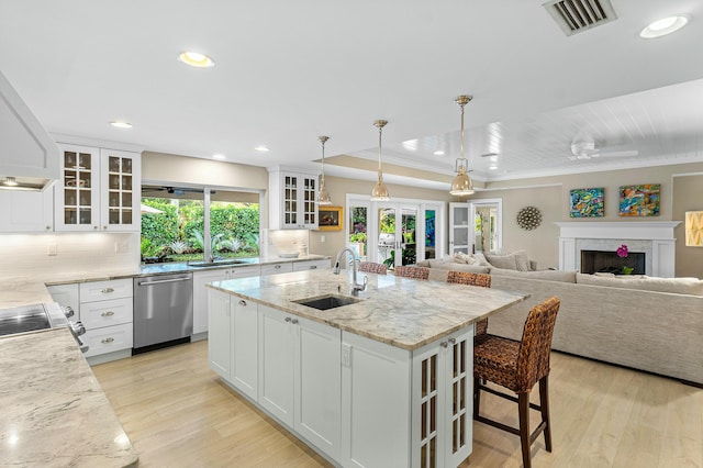 kitchen with dishwasher, light wood-style flooring, visible vents, and a sink