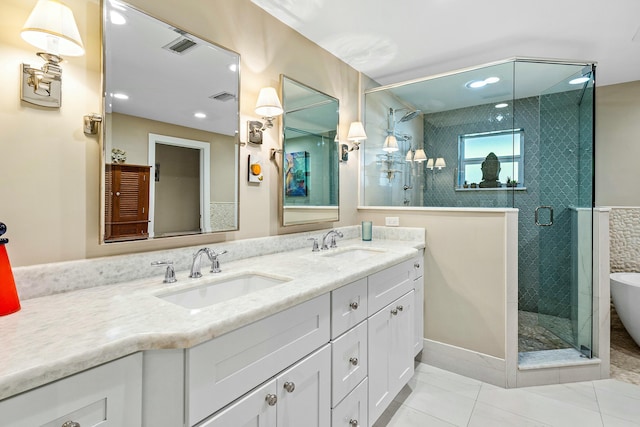 full bathroom with double vanity, visible vents, a shower stall, and a sink