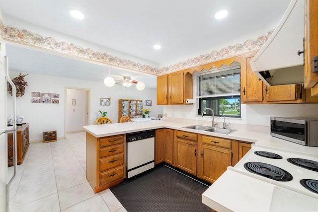 kitchen with under cabinet range hood, dishwasher, light countertops, a peninsula, and a sink