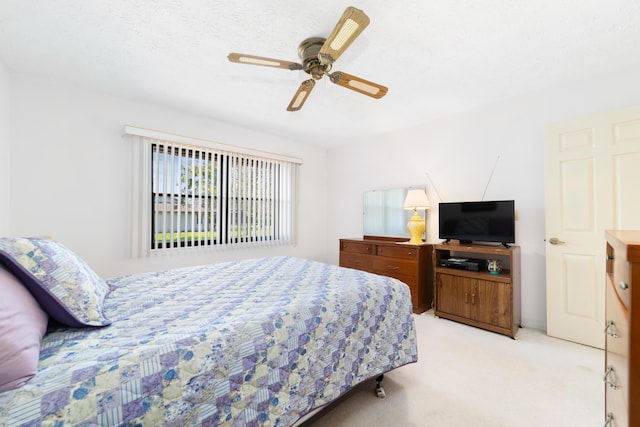 bedroom with a ceiling fan and light carpet