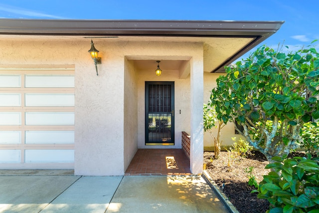 property entrance featuring a garage and stucco siding