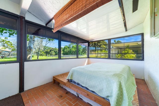 bedroom with multiple windows and brick floor