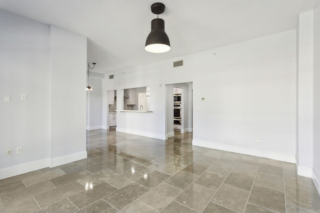 unfurnished living room with baseboards and visible vents