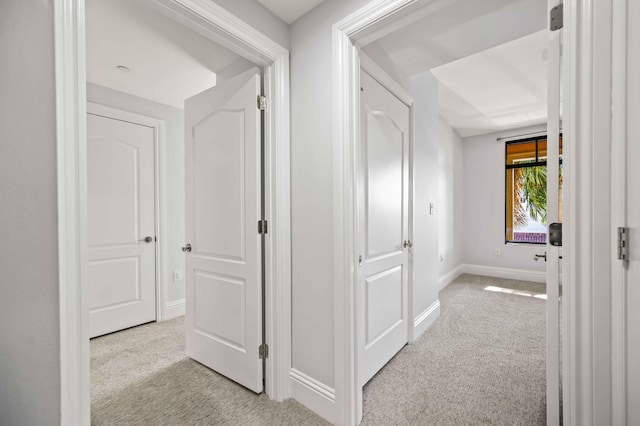 corridor with baseboards and carpet