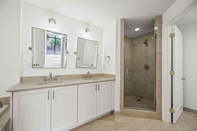 full bath with double vanity, a stall shower, and a sink