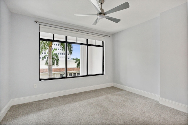 empty room with carpet, baseboards, and ceiling fan