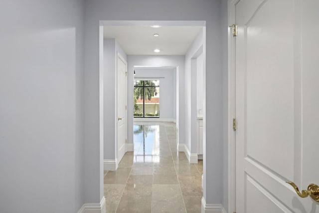 hallway with recessed lighting and baseboards