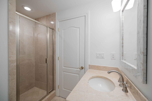 bathroom featuring a stall shower and a sink