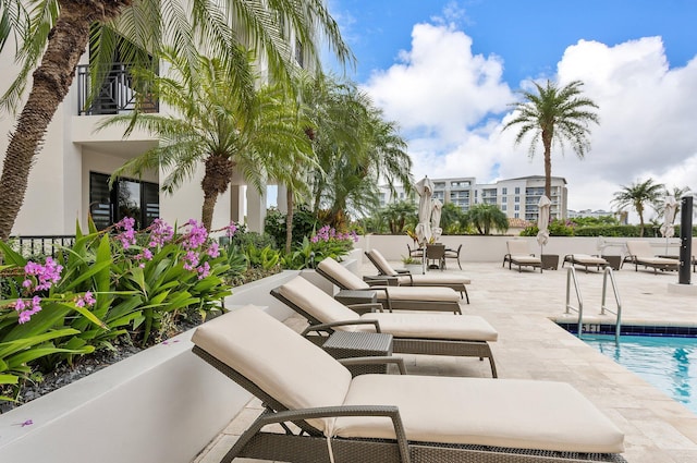 view of patio with a balcony and a community pool