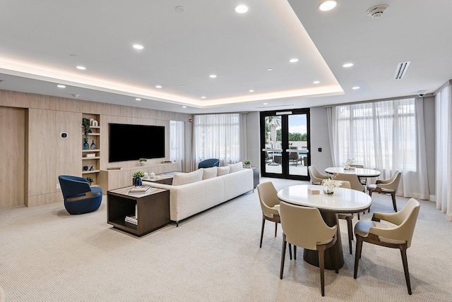 dining area featuring recessed lighting, a tray ceiling, light colored carpet, and built in features