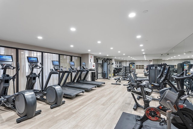 workout area featuring recessed lighting and light wood-style floors