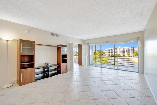 living area with light tile patterned floors, visible vents, a textured ceiling, and a city view