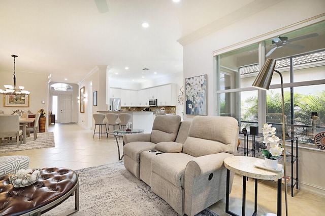 living room featuring light tile patterned floors, ceiling fan with notable chandelier, a healthy amount of sunlight, and ornamental molding