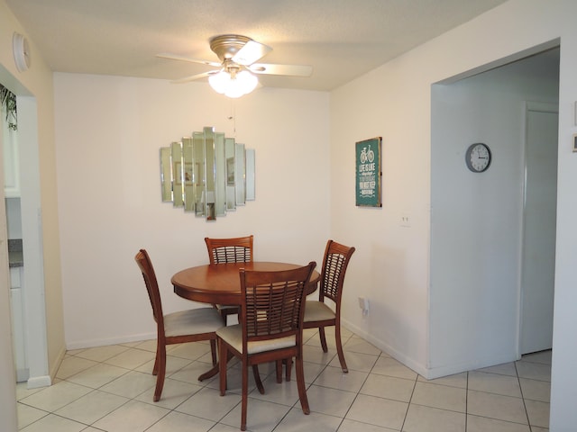 dining area featuring baseboards, light tile patterned flooring, and a ceiling fan