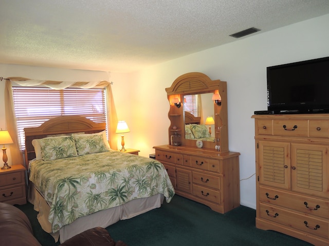 bedroom featuring visible vents, carpet floors, and a textured ceiling