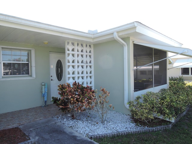 view of exterior entry with stucco siding