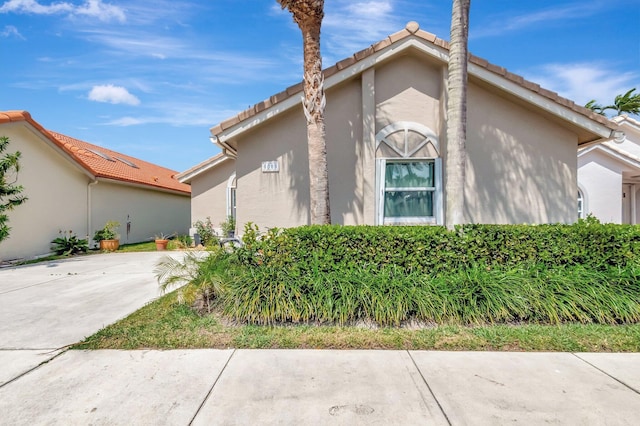 6089 Bay Isles Dr, Boynton Beach, FL 33437 - view of side of home featuring stucco siding, concrete driveway, and a tile roof