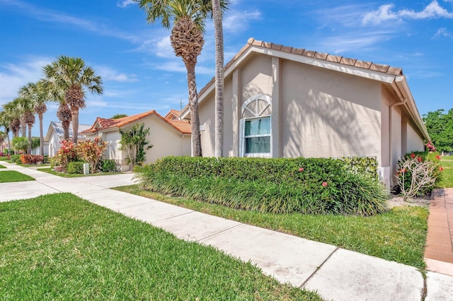 6089 Bay Isles Dr, Boynton Beach, FL 33437 - view of front of house with a front lawn, a tile roof, and stucco siding