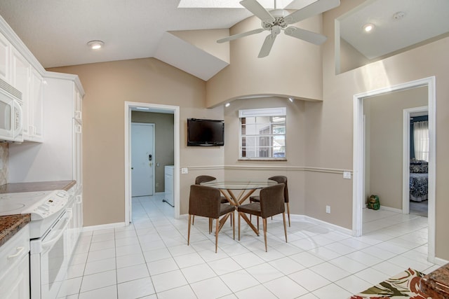 dining room featuring light tile patterned floors, ceiling fan, baseboards, and vaulted ceiling