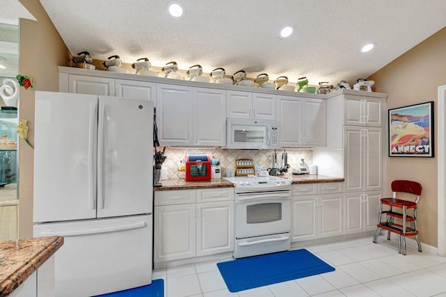 6089 Bay Isles Dr, Boynton Beach, FL 33437 - kitchen with light tile patterned floors, white appliances, tasteful backsplash, and white cabinetry