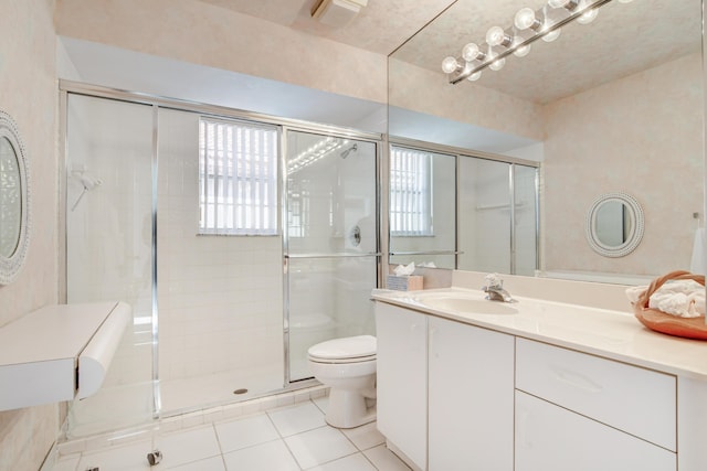 bathroom featuring tile patterned flooring, a stall shower, toilet, and vanity