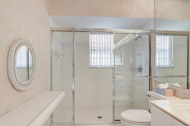 full bath with a stall shower, toilet, and vanity