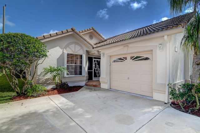 view of front of house featuring a tile roof, stucco siding, concrete driveway, and a garage