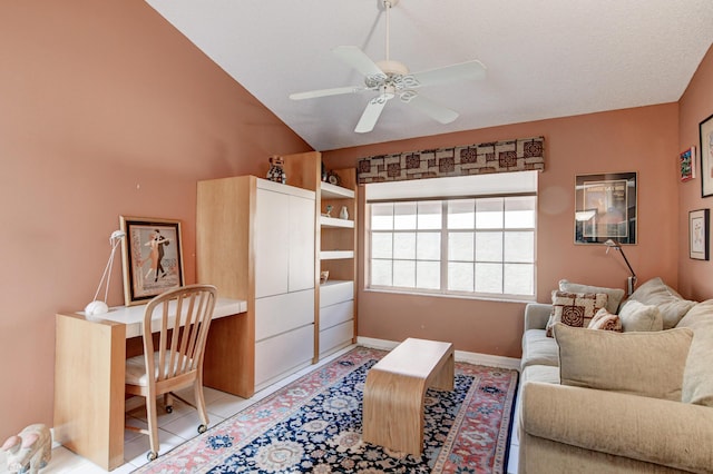 living area featuring lofted ceiling, light tile patterned floors, a ceiling fan, and baseboards