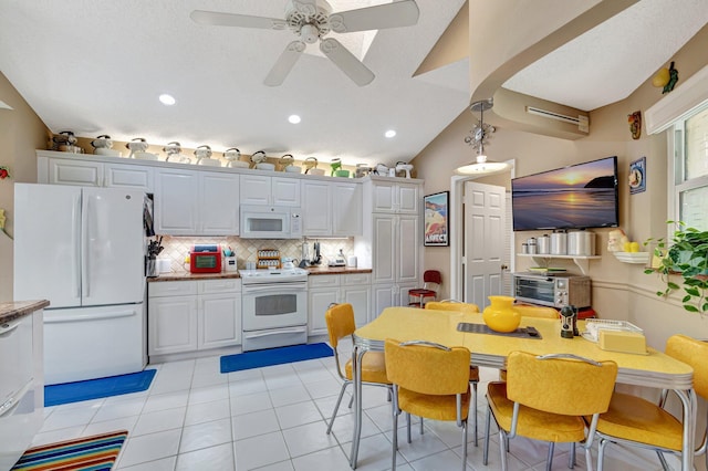 6089 Bay Isles Dr, Boynton Beach, FL 33437 - kitchen featuring backsplash, vaulted ceiling, white appliances, white cabinetry, and a ceiling fan