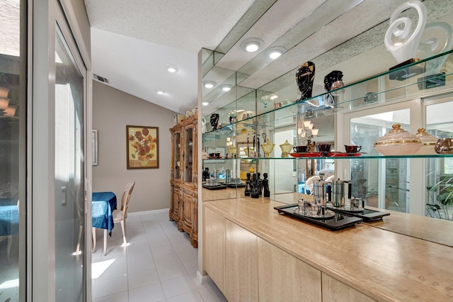 6089 Bay Isles Dr, Boynton Beach, FL 33437 - bar with visible vents, a textured ceiling, light tile patterned floors, baseboards, and vaulted ceiling