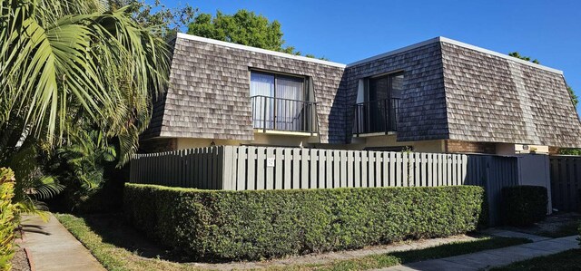 335 S Waverly Pl Unit 7A, Vero Beach, FL 32960 - view of side of home featuring mansard roof and fence