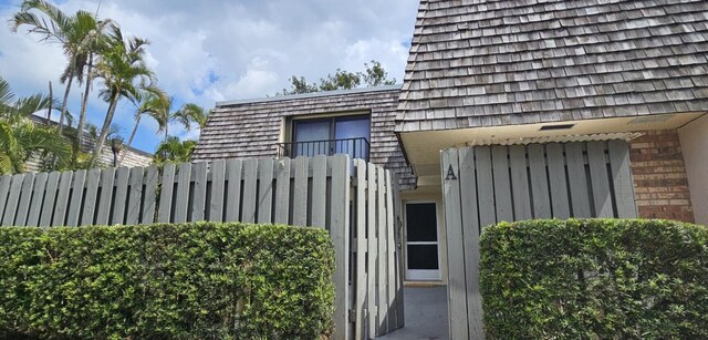 335 S Waverly Pl Unit 7A, Vero Beach, FL 32960 - view of front of home with a balcony, mansard roof, and a fenced front yard