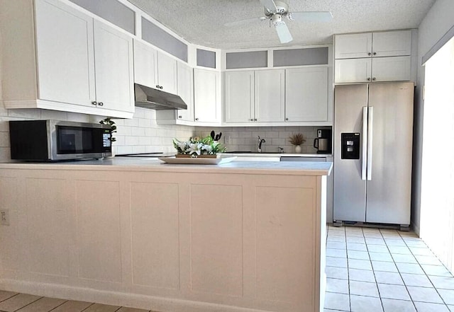 335 S Waverly Pl Unit 7A, Vero Beach, FL 32960 - kitchen with under cabinet range hood, backsplash, appliances with stainless steel finishes, and a peninsula