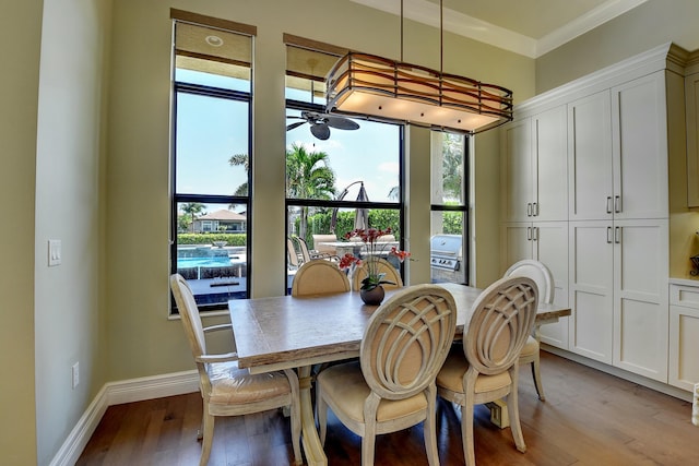 dining area with baseboards, light wood-style floors, ceiling fan, and crown molding