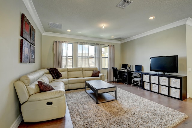 living area featuring visible vents, wood finished floors, and crown molding