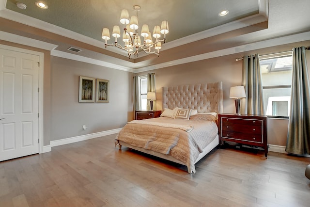 bedroom with a tray ceiling, baseboards, wood finished floors, and ornamental molding