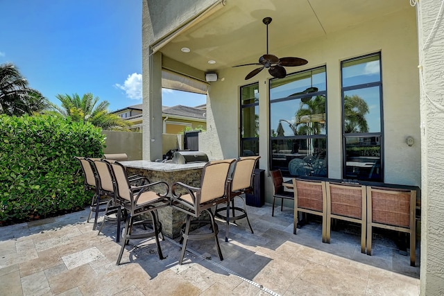 view of patio / terrace with outdoor dry bar, a ceiling fan, and fence