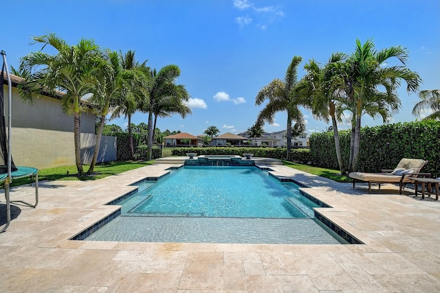 view of pool featuring a patio, a trampoline, fence, and a pool with connected hot tub