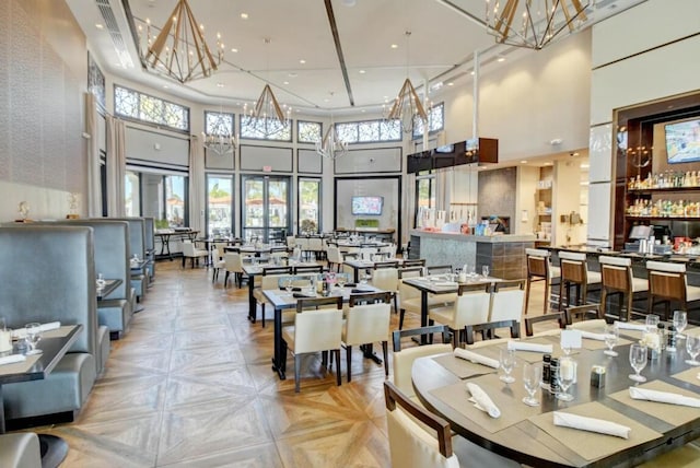 dining room featuring a notable chandelier, recessed lighting, and a high ceiling