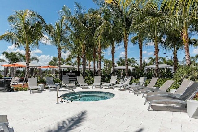 view of pool featuring central air condition unit, a community hot tub, and a patio area